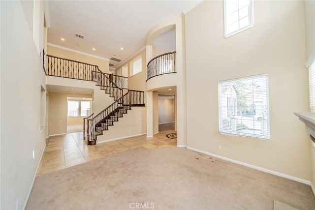 36368 Par Ln, Beaumont, CA 92223 - carpeted entryway with a towering ceiling, stairway, baseboards, arched walkways, and tile patterned flooring