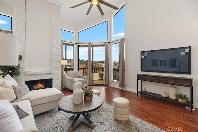 27869 Mazagon Unit 111, Mission Viejo, CA 92692 - living room featuring a ceiling fan, a towering ceiling, wood finished floors, healthy amount of natural light, and a brick fireplace