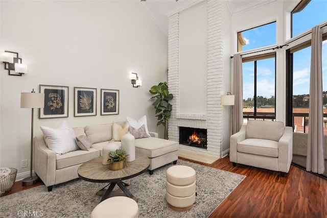 27869 Mazagon Unit 111, Mission Viejo, CA 92692 - living area featuring ornamental molding, a high ceiling, dark wood-type flooring, a brick fireplace, and baseboards