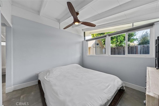 bedroom featuring beamed ceiling, a ceiling fan, and baseboards