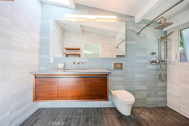 bathroom featuring vanity, tile walls, tiled shower, and lofted ceiling