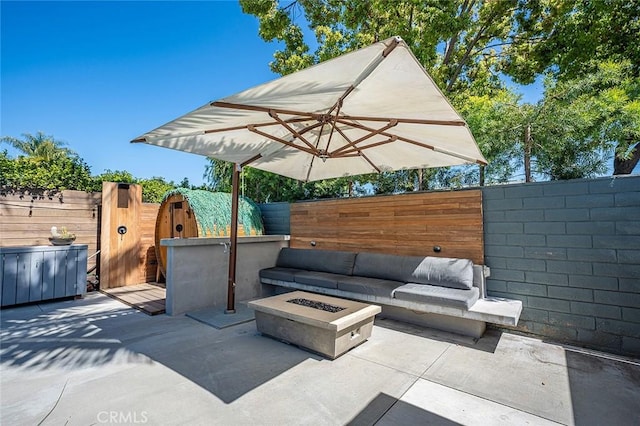 view of patio / terrace featuring fence private yard and an outdoor living space with a fire pit