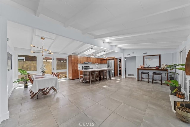 dining space with light tile patterned flooring, an inviting chandelier, visible vents, and vaulted ceiling with beams