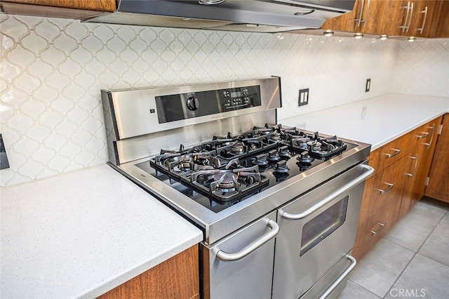 kitchen with brown cabinetry, light countertops, and double oven range