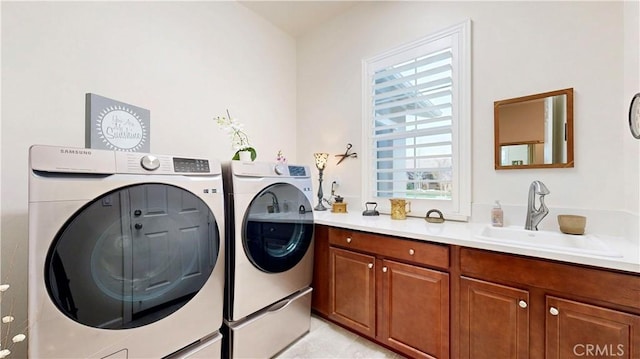 laundry area with a sink, cabinet space, and washer and dryer