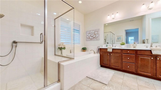 bathroom with plenty of natural light, double vanity, tile patterned floors, a stall shower, and a garden tub