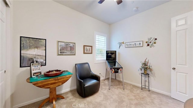 living area featuring baseboards, carpet flooring, and a ceiling fan