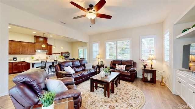 living room featuring visible vents, light wood finished floors, baseboards, recessed lighting, and a ceiling fan
