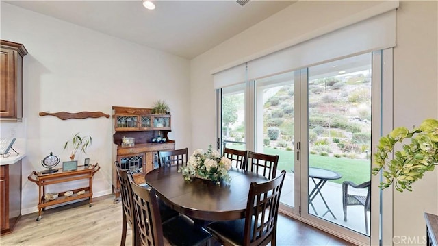 dining space featuring baseboards and light wood-type flooring