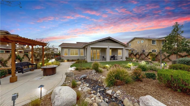 back of property at dusk featuring a fire pit, fence, a pergola, and a patio area