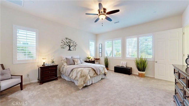 bedroom with baseboards, multiple windows, and light colored carpet