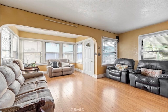 27 E Platt St, Long Beach, CA 90805 - living area with plenty of natural light, arched walkways, baseboards, wood finished floors, and a textured ceiling