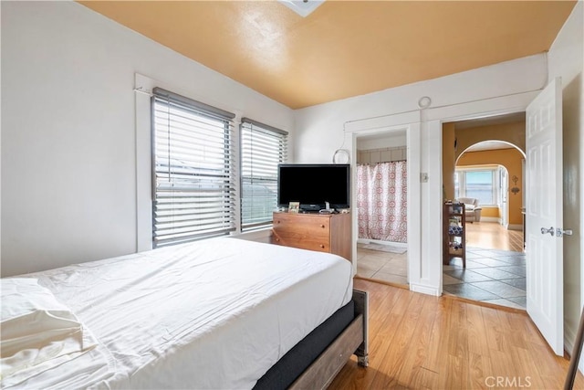 27 E Platt St, Long Beach, CA 90805 - bedroom with light wood finished floors, arched walkways, and ensuite bath
