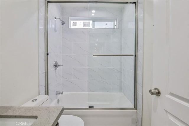 full bathroom with vanity, enclosed tub / shower combo, and toilet