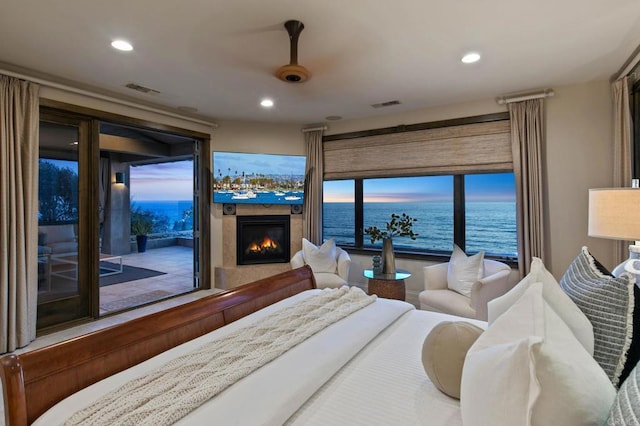 bedroom with a glass covered fireplace, access to outside, recessed lighting, and visible vents