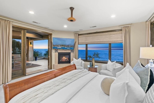 bedroom featuring access to outside, recessed lighting, a glass covered fireplace, and visible vents