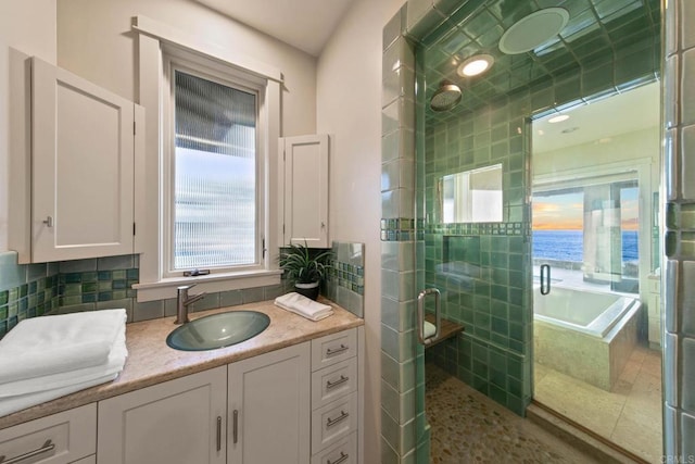 bathroom with vanity, decorative backsplash, a bath, and a shower stall