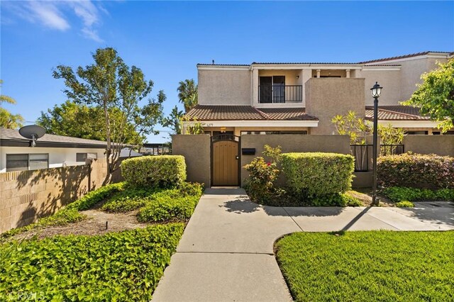 6279 Lincoln Ave, Buena Park, CA 90620 - view of front of home with a fenced front yard, a gate, stucco siding, a balcony, and a tiled roof