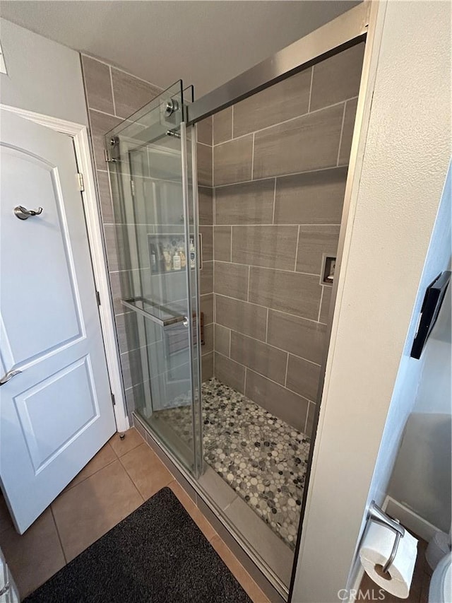 full bathroom featuring tile patterned floors and a stall shower