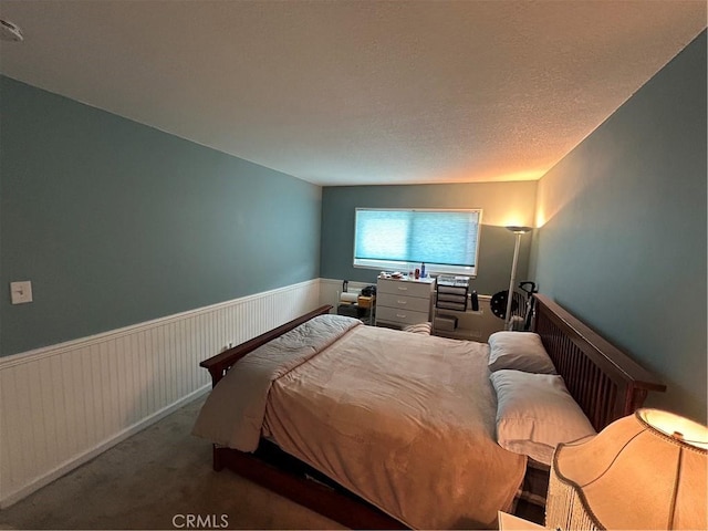 bedroom featuring wainscoting and carpet