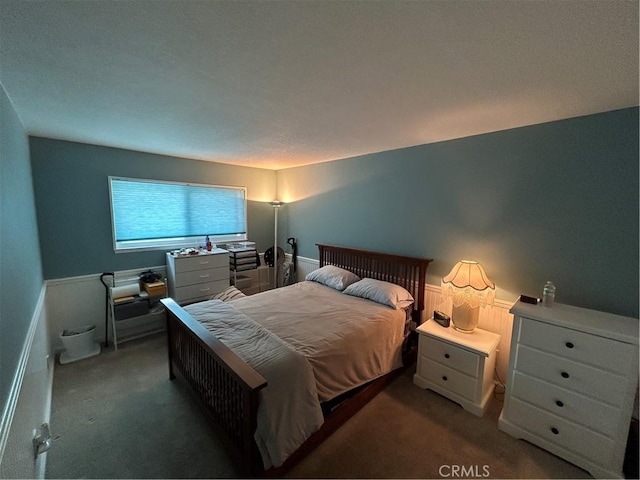 carpeted bedroom with a wainscoted wall