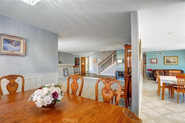 18137 Galatina St, Rowland Heights, CA 91748 - dining area featuring stairway, a wainscoted wall, a fireplace, and light tile patterned floors