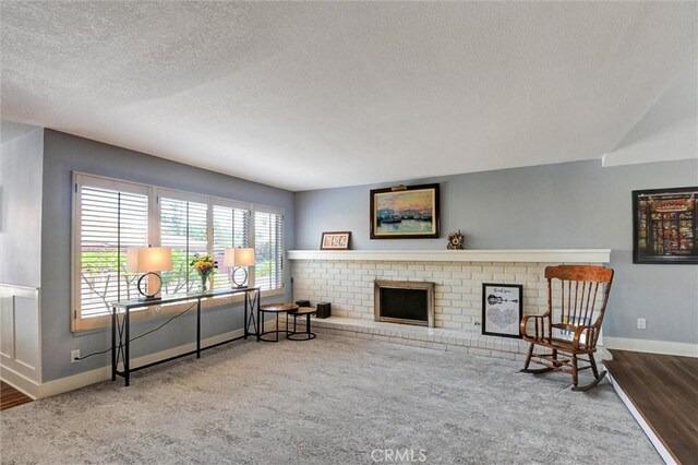 18137 Galatina St, Rowland Heights, CA 91748 - sitting room featuring a textured ceiling, a fireplace, carpet, and wood finished floors