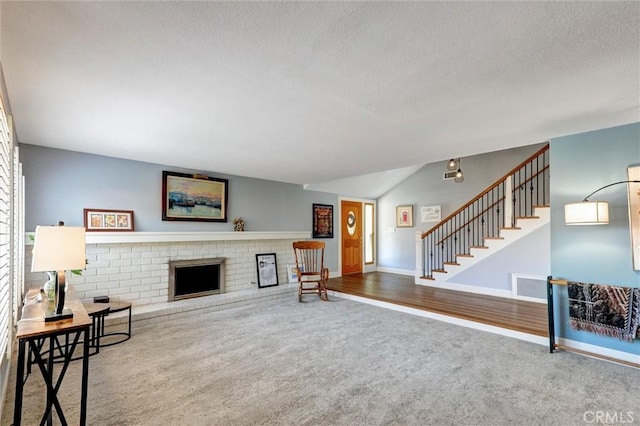 18137 Galatina St, Rowland Heights, CA 91748 - unfurnished living room featuring carpet flooring, a textured ceiling, stairs, a fireplace, and vaulted ceiling