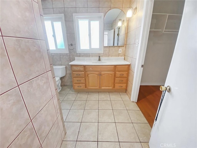 13827 Olathe Rd, Apple Valley, CA 92307 - bathroom with tile patterned floors, tile walls, toilet, and vanity