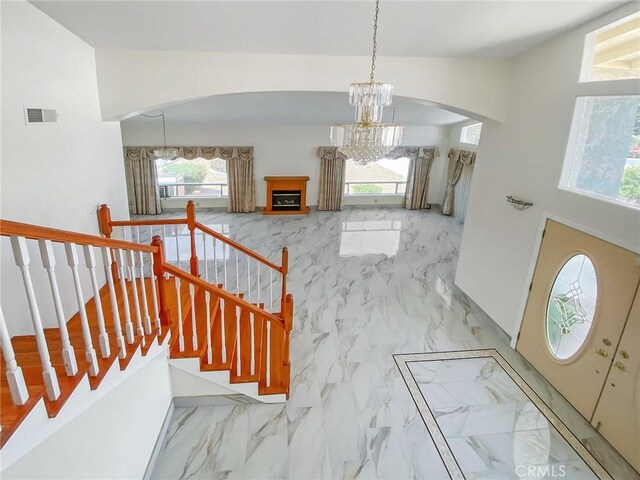 13827 Olathe Rd, Apple Valley, CA 92307 - entryway with arched walkways, a chandelier, plenty of natural light, and marble finish floors