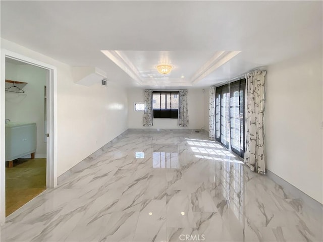 13827 Olathe Rd, Apple Valley, CA 92307 - unfurnished living room featuring a tray ceiling and light marble finish floors