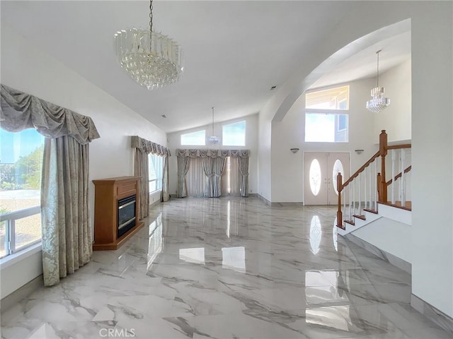 13827 Olathe Rd, Apple Valley, CA 92307 - unfurnished living room with a chandelier, arched walkways, light marble finish flooring, high vaulted ceiling, and stairway