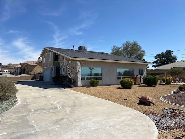 13827 Olathe Rd, Apple Valley, CA 92307 - view of front of home featuring an attached garage, concrete driveway, and stucco siding