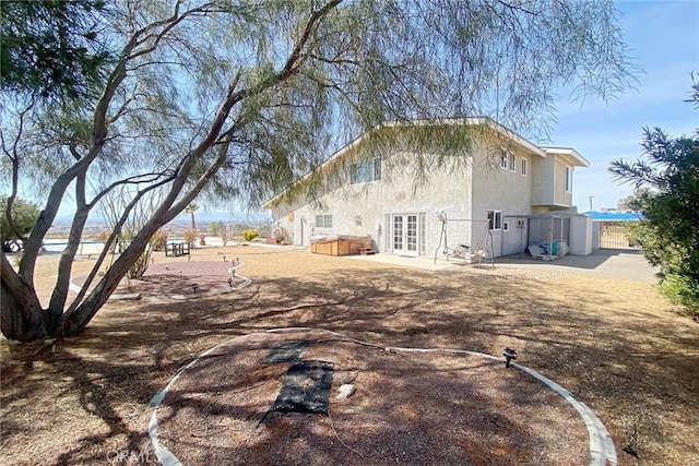 13827 Olathe Rd, Apple Valley, CA 92307 - rear view of property with a hot tub, french doors, stucco siding, a patio, and fence