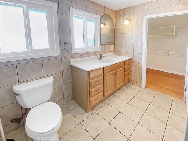 13827 Olathe Rd, Apple Valley, CA 92307 - bathroom with tile walls, tile patterned floors, vanity, and toilet