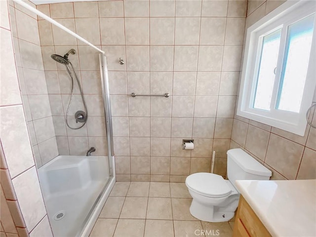13827 Olathe Rd, Apple Valley, CA 92307 - full bathroom featuring tile walls, a shower stall, toilet, vanity, and tile patterned floors