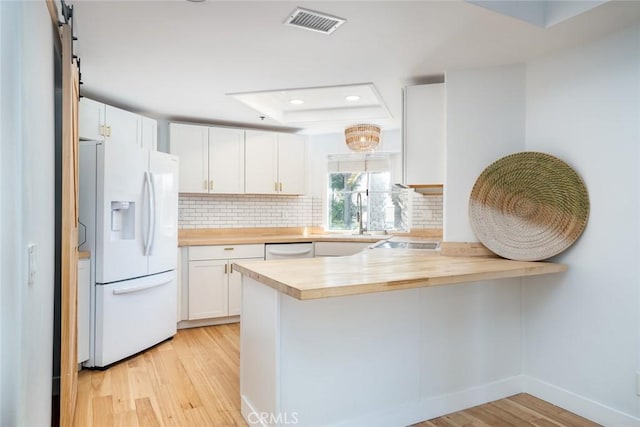 310 Lake St Unit 216, Huntington Beach, CA 92648 - kitchen with a sink, butcher block countertops, a peninsula, white appliances, and visible vents