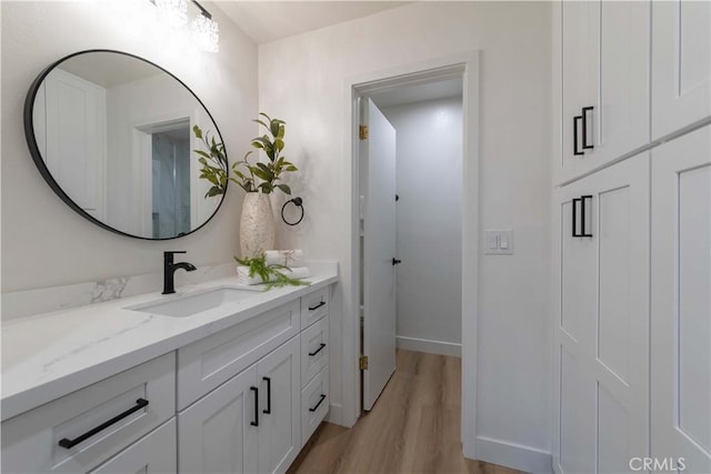 bathroom with vanity, baseboards, and wood finished floors