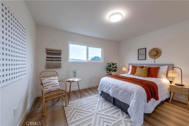 bedroom with baseboards and wood finished floors