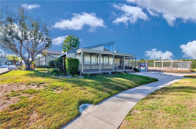 exterior space featuring fence, a front lawn, and a porch
