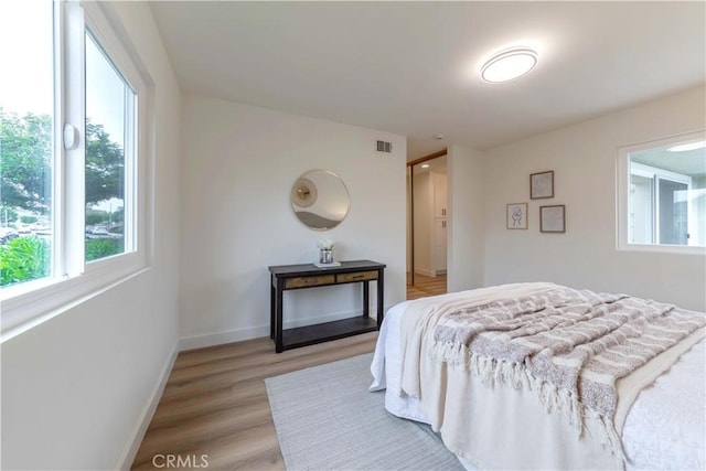 bedroom featuring light wood-style floors, baseboards, and visible vents