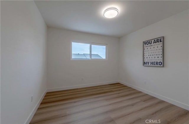unfurnished room featuring light wood finished floors and baseboards