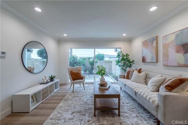 living room featuring recessed lighting, ornamental molding, baseboards, and light wood-type flooring