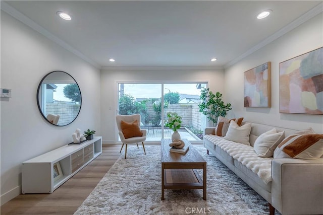 living room featuring crown molding, baseboards, light wood finished floors, and recessed lighting