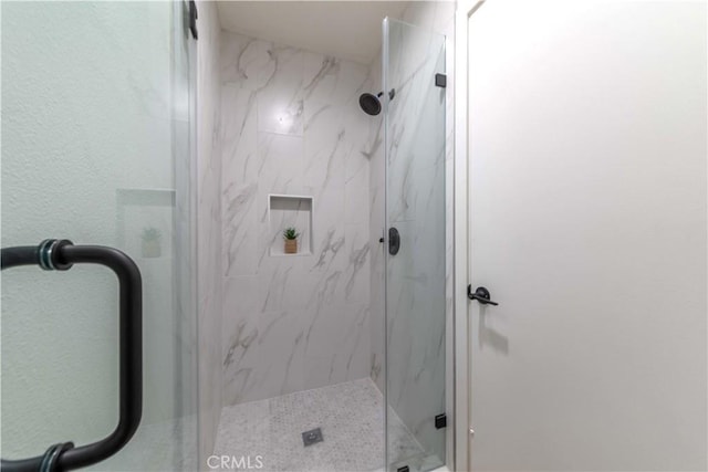 full bathroom featuring a marble finish shower