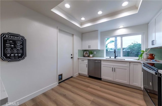 kitchen featuring crown molding, dishwasher, a sink, a tray ceiling, and electric range