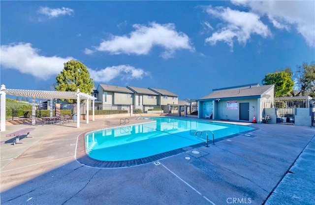 pool with fence, a pergola, and a patio area