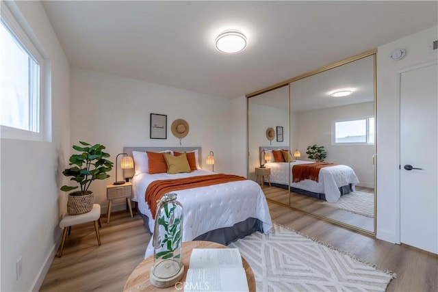 bedroom with baseboards, a closet, and light wood-style floors