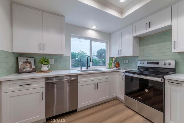 kitchen with light countertops, white cabinets, a sink, and appliances with stainless steel finishes