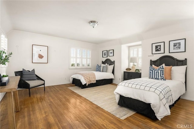 bedroom featuring wood finished floors and vaulted ceiling